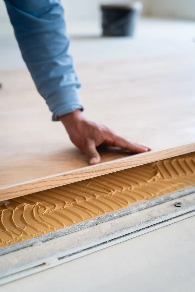 Carpintero profesional montando el parquet con pegamento en una obra de Rez Estudio en barrio de Chamberí
