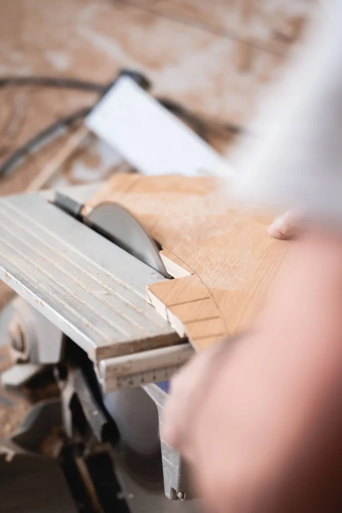 Carpintero dando la forma al parquet con sierra circular