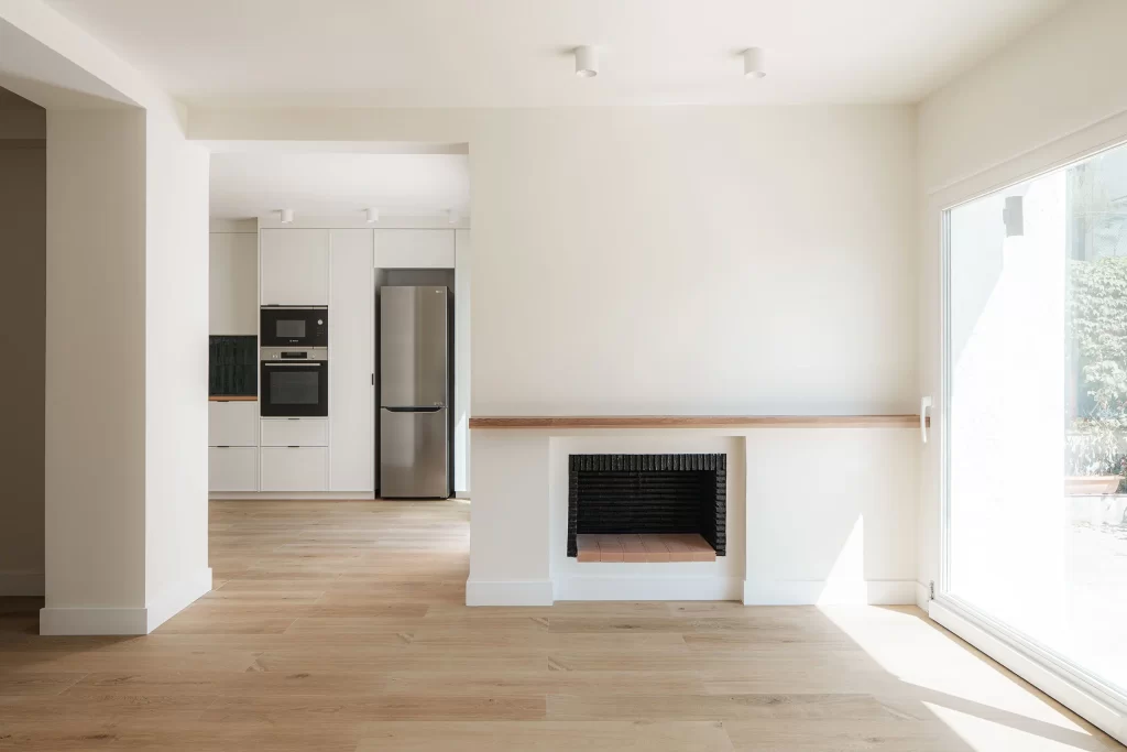 Fotografía de interiores - Salón con chimenea que abre a la cocina y los exteriores