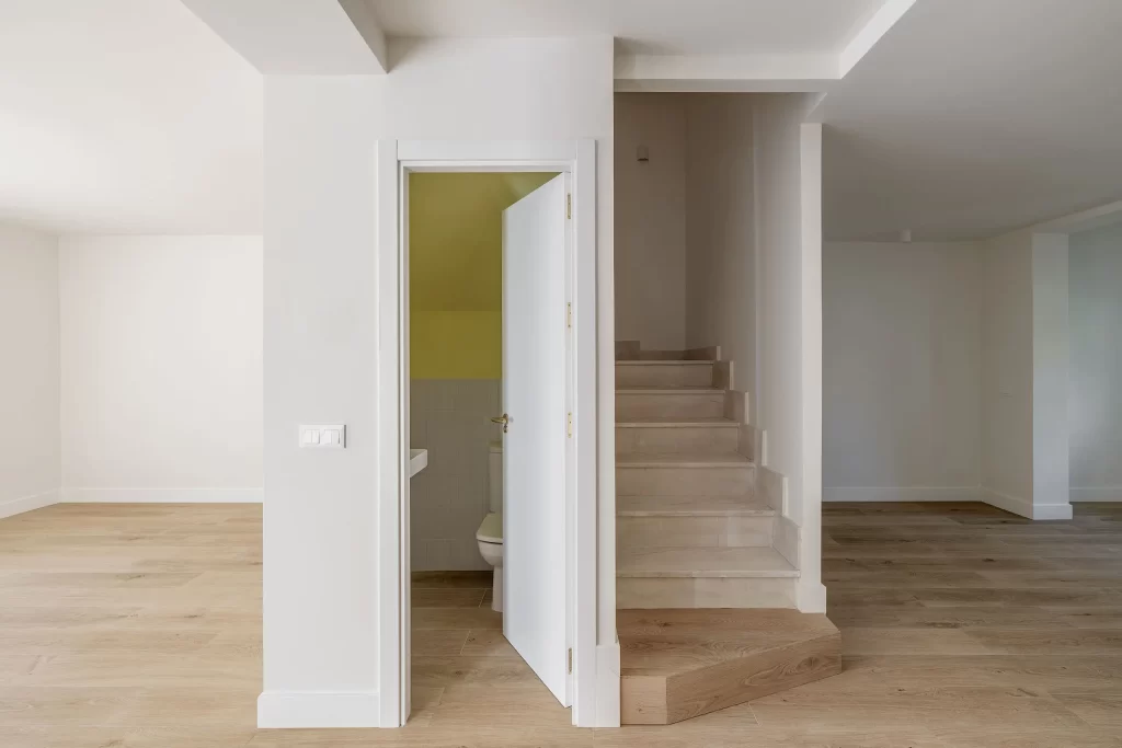 Fotografía de interiores - Unión de espacios en la planta baja - Salón, aseo, escaleras y comedor