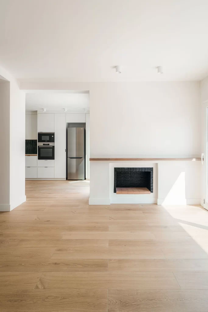 Fotografía de interiores - Salón con chimenea que abre a la cocina
