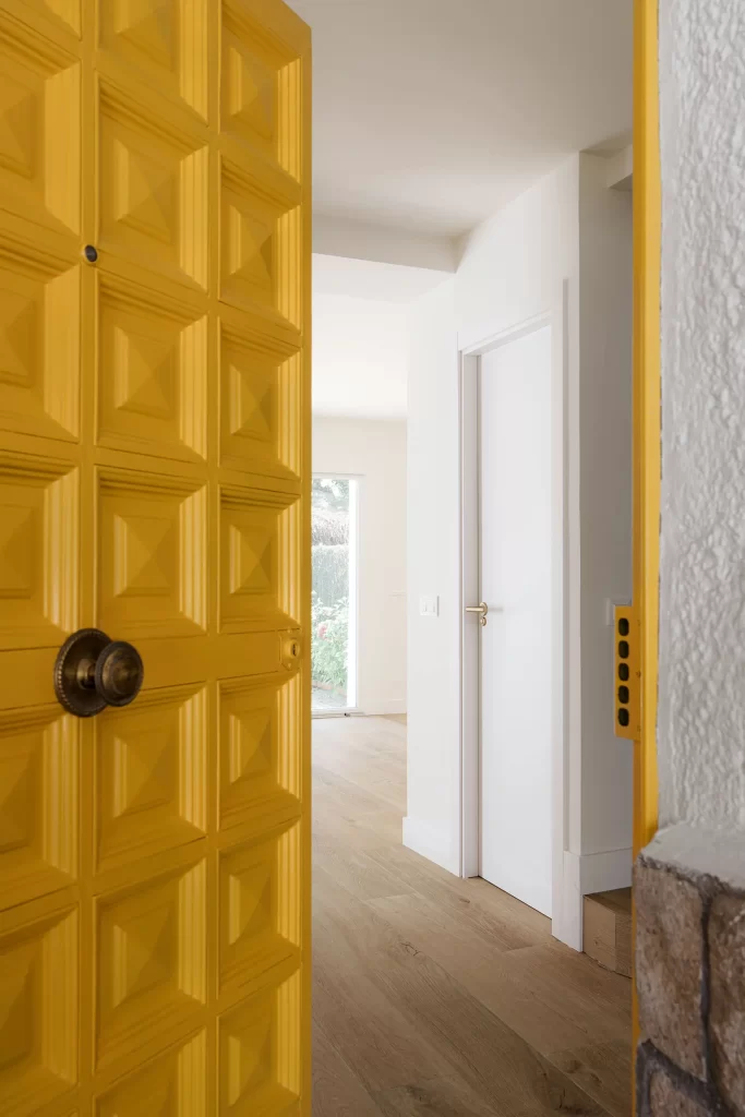 Fotografía de interiores - la vista desde la entrada de la casa con la puerta amarilla